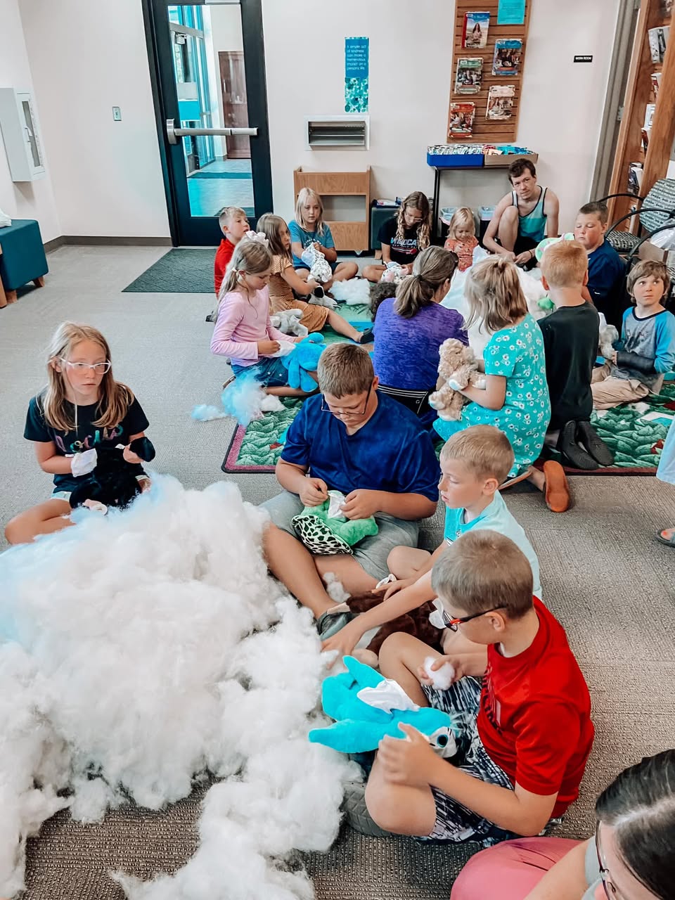 Children and adults at a library workshop building their Furry Friends together
