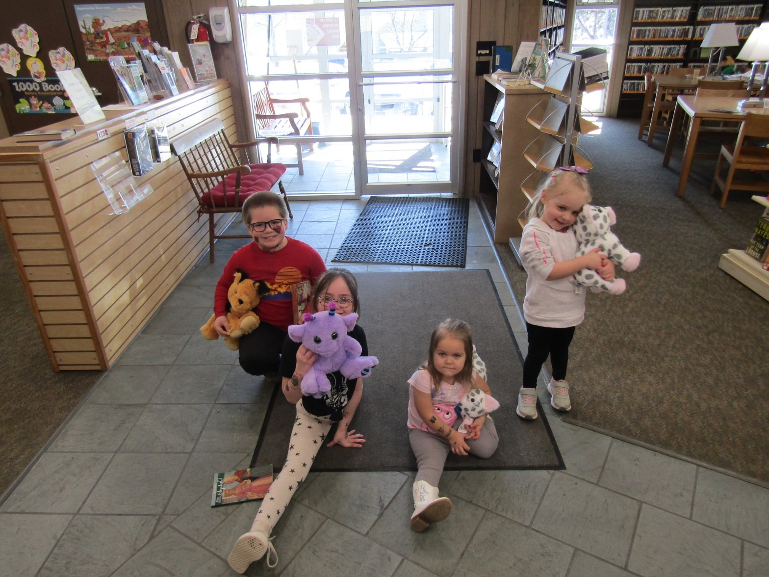 Children gathered around a craft table with their handmade plush friends