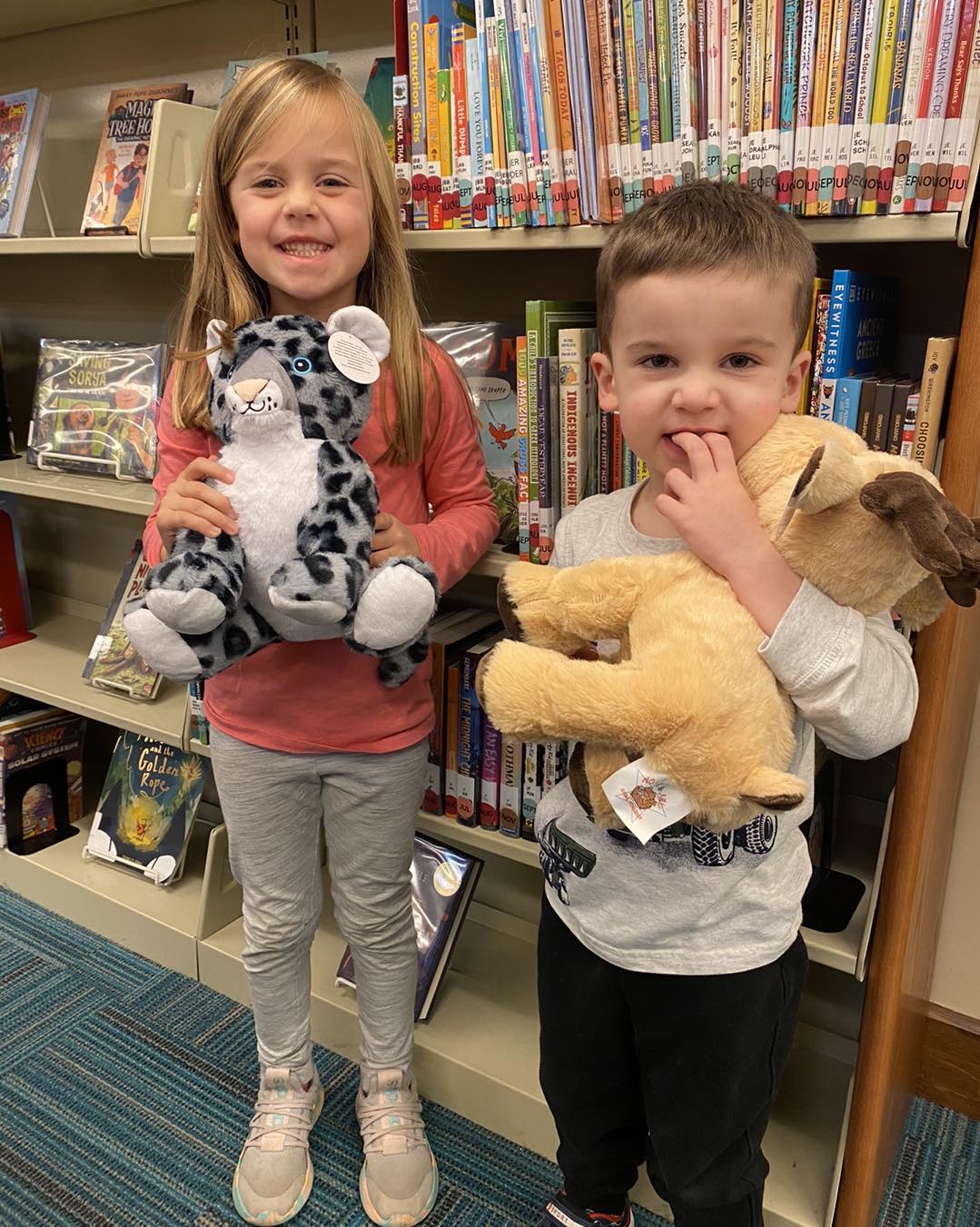 A child proudly showing off a handmade Furry Friend at a library workshop