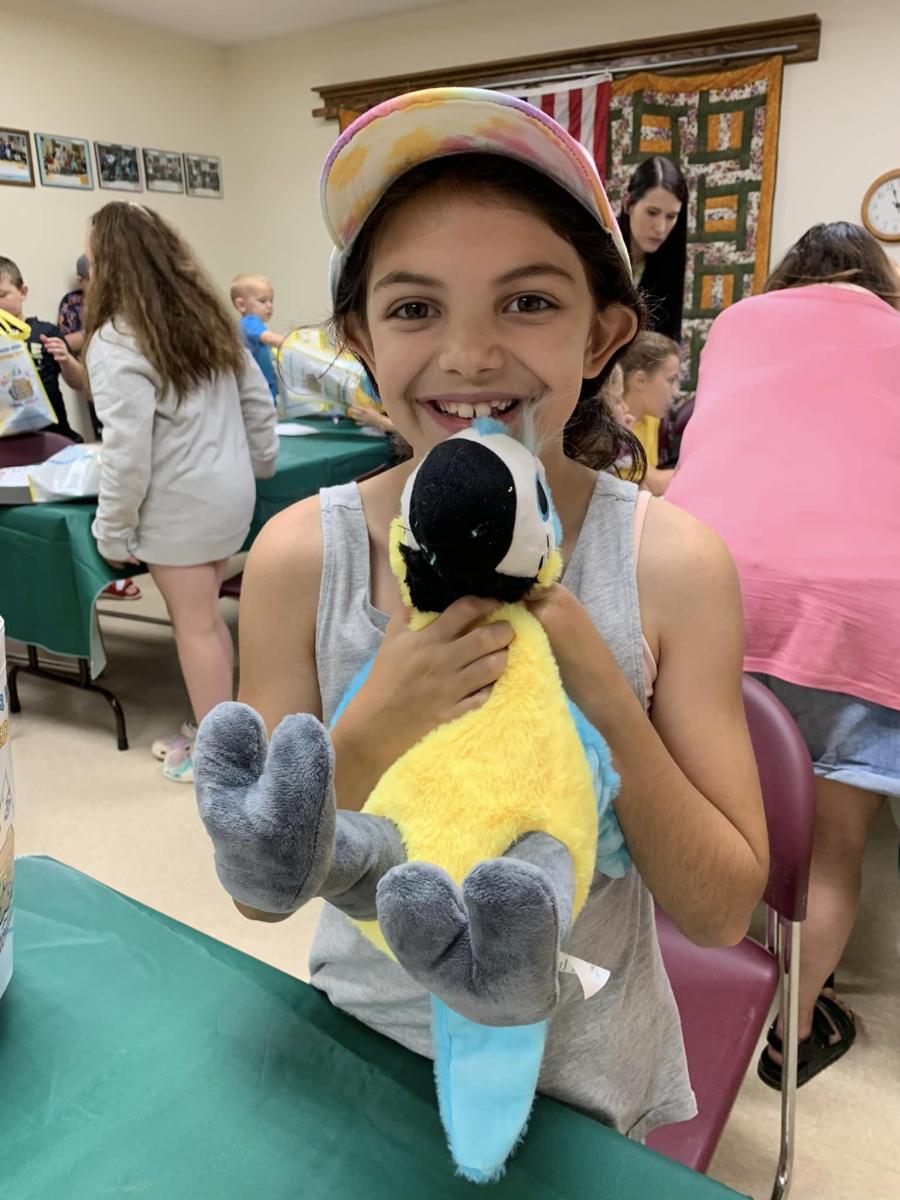 A child hand-stuffing their teddy bear at a workshop