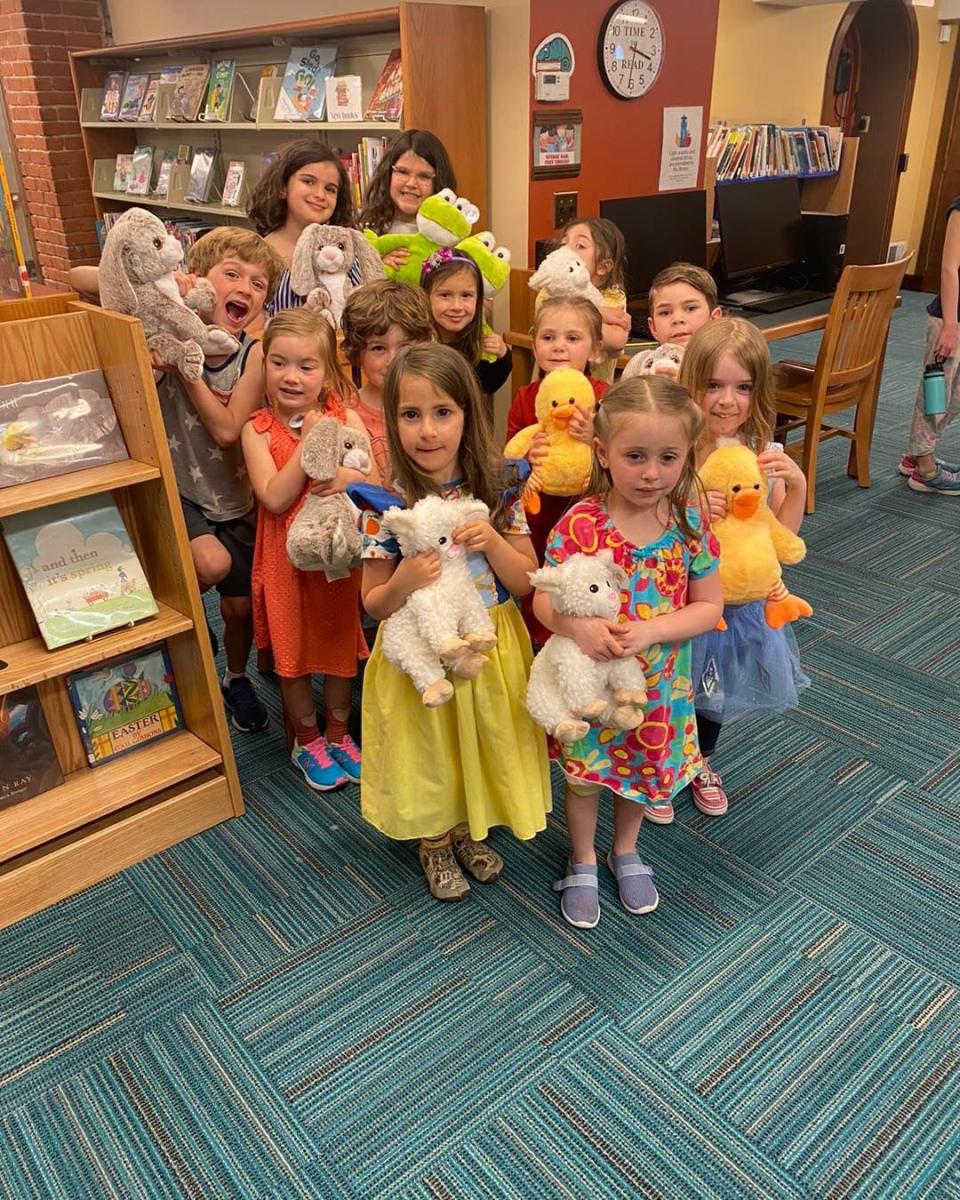 Children proudly holding the stuffed animals they created at a workshop